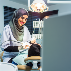 רופא שיניים מקצועי מבצע ניקוי שיניים במרפאה מודרנית ומוארת עם מטופל יושב בכיסא השיניים.